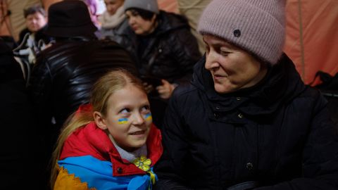 Hanna, right, and her daughter Nastya sit together in the phone-charging tent.