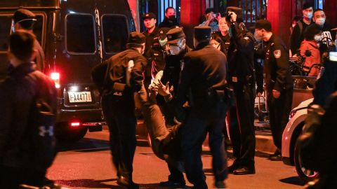 A protester is arrested by police in Shanghai on Sunday night.