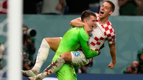 Croatia's Mario Pasalic celebrates with goalkeeper Dominik Livakovic after scoring the winning penalty against Brazil at the 2022 World Cup.