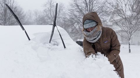 A Buffalo, New York, resident cleans snow off her car Saturday.