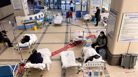 Covid patients lie in the lobby of a hospital in the megacity of Chongqing as space in wards runs out.