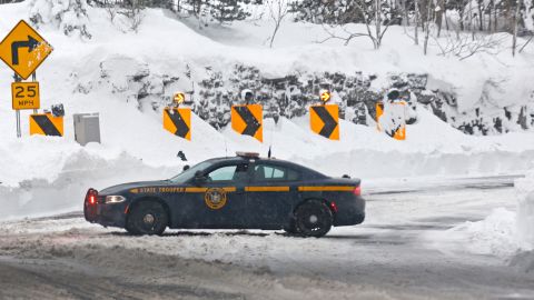 A New York state trooper car blocks the entrance to Route 198 on Tuesday after a winter storm in Buffalo.