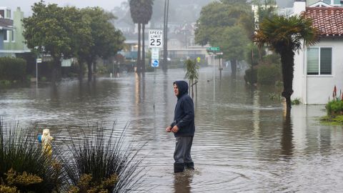 A man wades through a flooded street in Aptos Monday. 