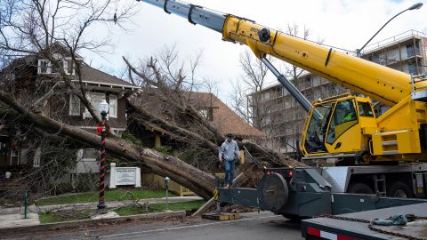 Crane operator Ricky Kapuschinsky prepares to lift uprooted trees Sunday in Sacramento, California.