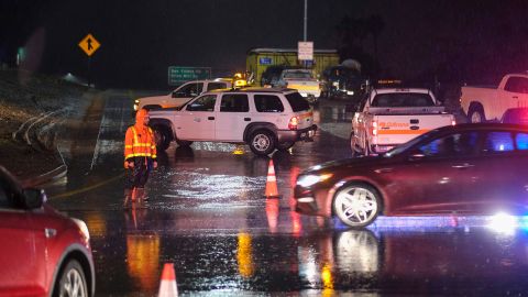 A Caltrans worker directs traffic at a freeway entrance as the U.S. Freeway 101 is closed near Montecito, California, Monday.