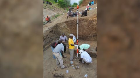 Members of the excavation team plot and record the position of fossils and artifacts at the Nyayanga site in July 2017.
