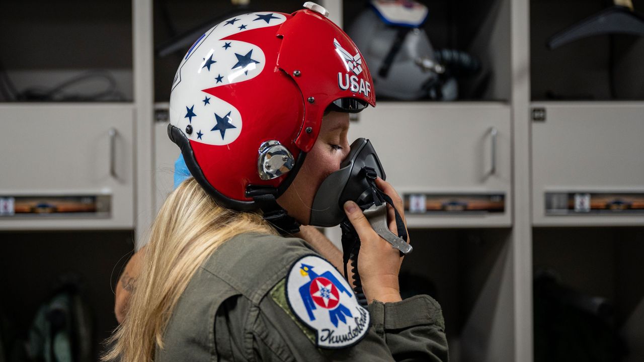 Britzky practices putting on her oxygen mask in preparation for her flight. During air show performances, the Thunderbirds fly both F-16 C and D block models, which, while differing in seating capacities, both reach speeds of up to 1,500 miles per hour and altitudes of 50,000 feet.