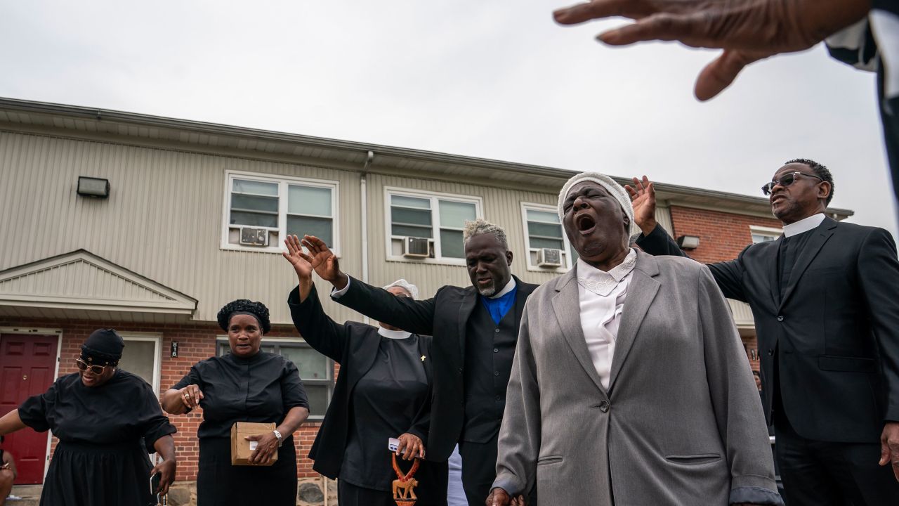 Members of the Kingdom Life Church pray at the site of a mass shooting in the Brooklyn Homes neighborhood on July 2, 2023.