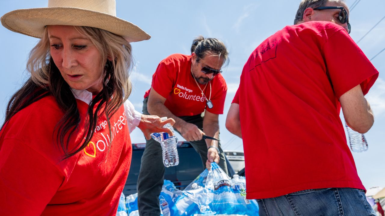 Volunteers organize water bottles for homeless people in Phoenix on Friday as the city continued to bake.  i