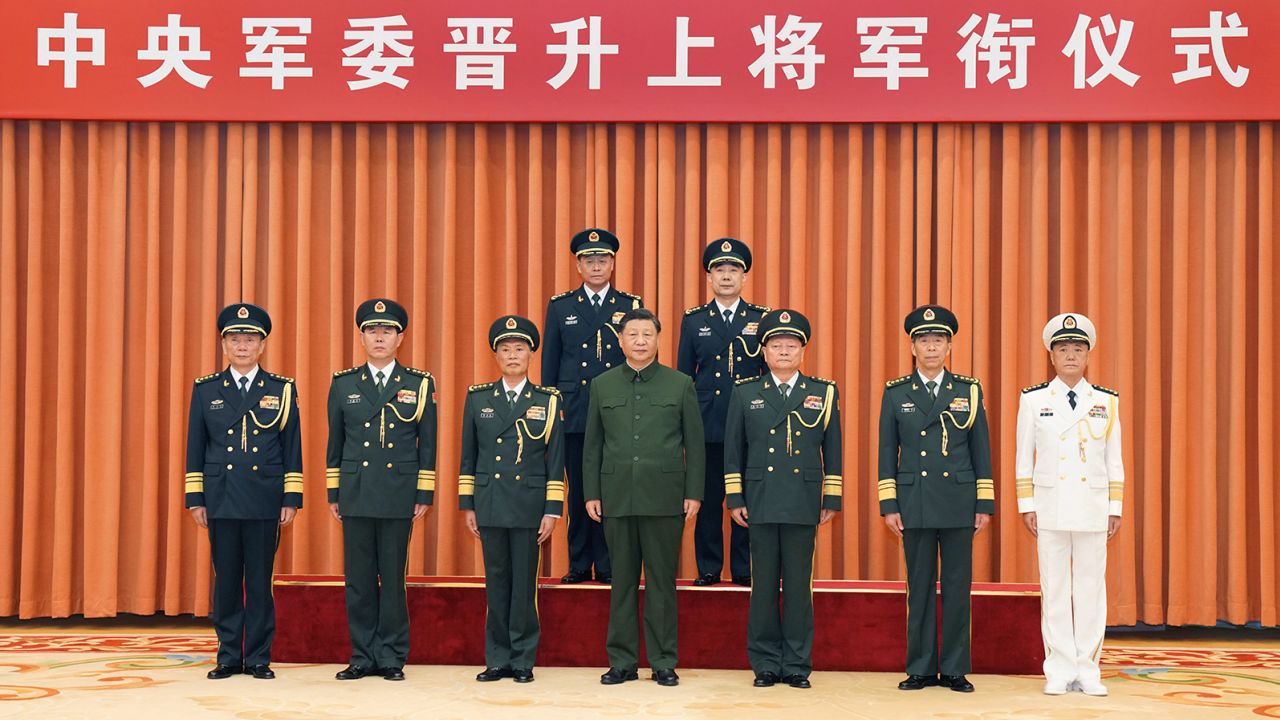 Chinese leader Xi Jinping, center, with new Rocket Force leadership Wang Houbin, back left, and Xu Xisheng, back right, after their promotion to the rank of general in Beijing on July 31, 2023. 