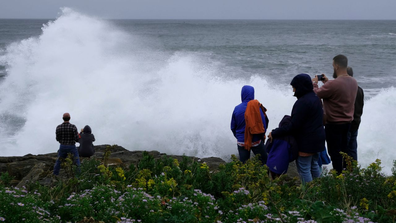 People watch rough surf and waves, remnants of Tropical Storm Lee, crash along the shore of Bailey Island, Maine, on Saturday.