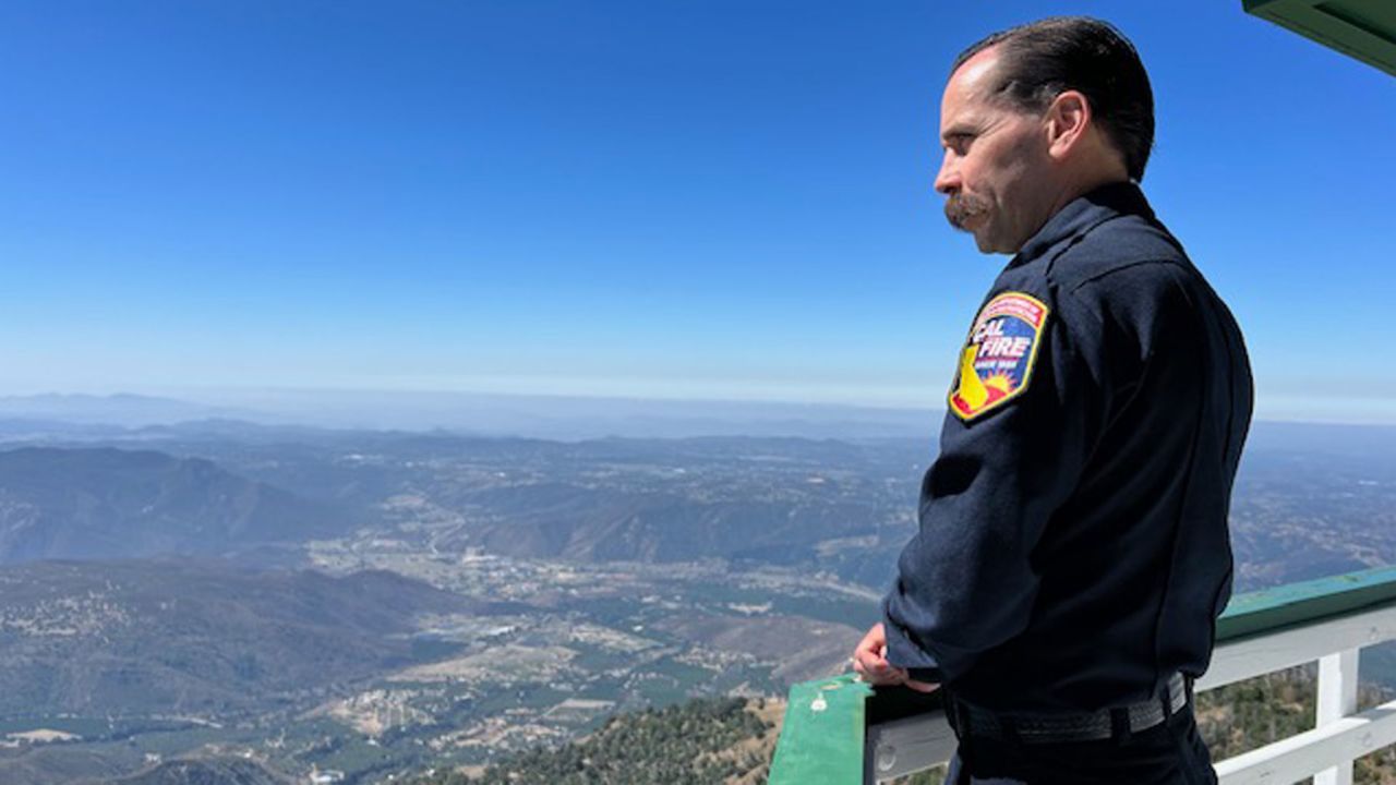 Cal Fire staff chief for fire intelligence Phillip SeLegue stands on a lookout tower in San Diego County. He says AI won't replace the towers but enhance fire suppression efforts.