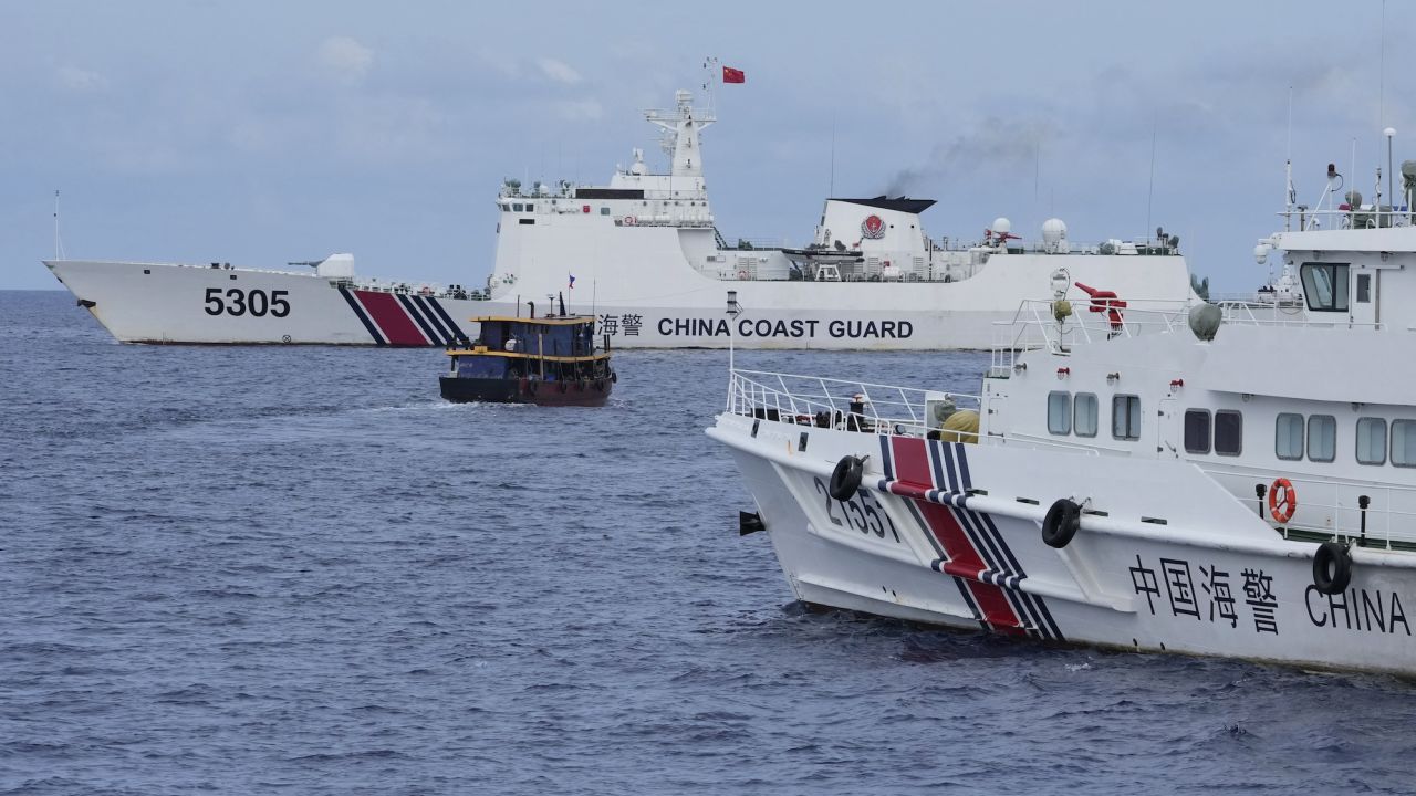 A Philippine supply boat, center, maneuvers around Chinese coast guard ships as they tried to block its way near Second Thomas Shoal, locally known as Ayungin Shoal, at the disputed South China Sea on August 22.