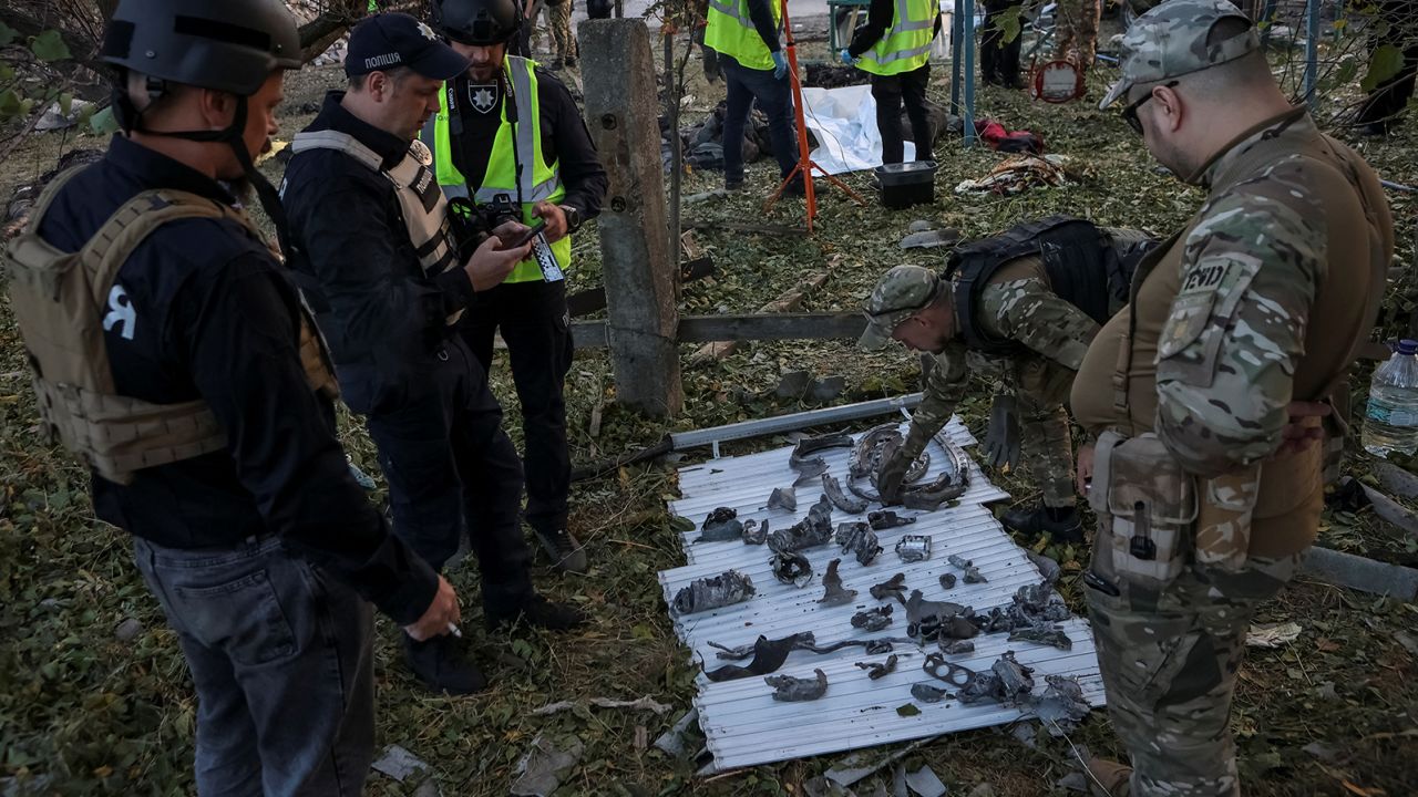 Police and military experts work at the site of a Russian military strike in Hroza.