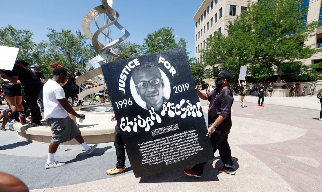 Demonstrators carried a giant placard during protests on June 27, 2020, outside the police department in Aurora.